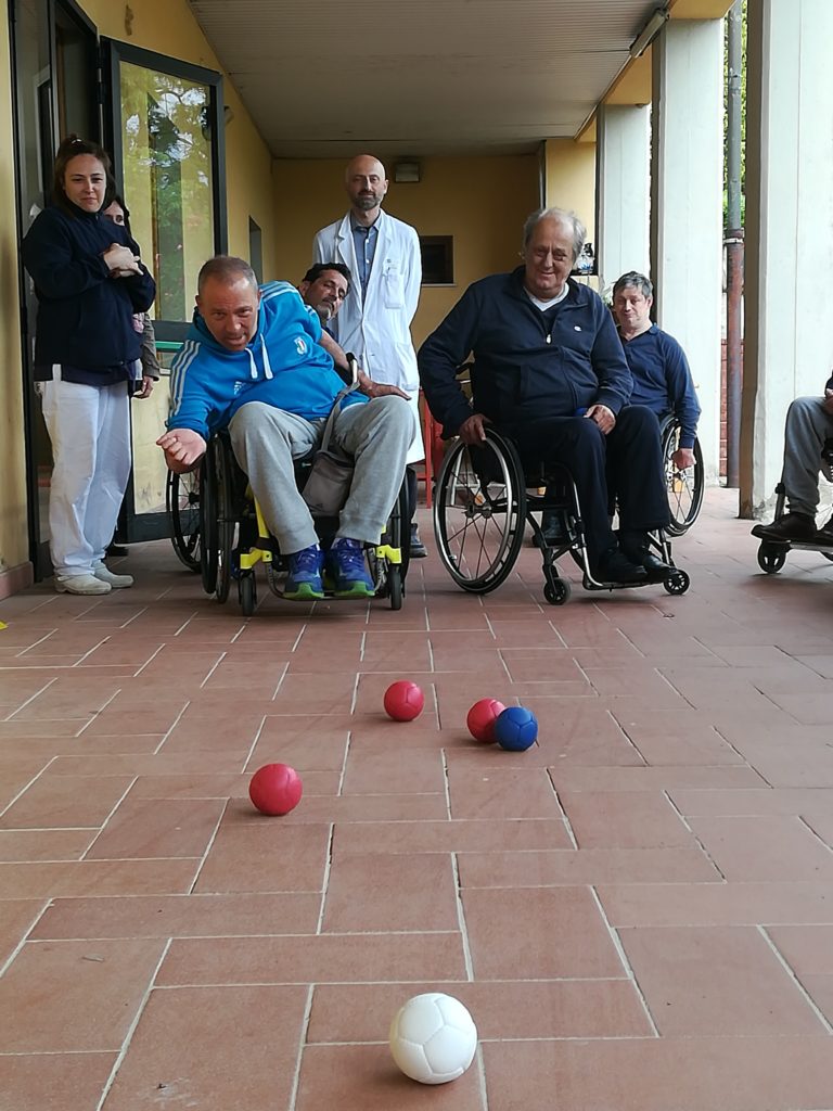 un istruttore FIB Toscana fa giocare a bocce gli ospiti del centro Villa Il Sorriso