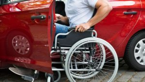 un disabile sale su un'auto rossa